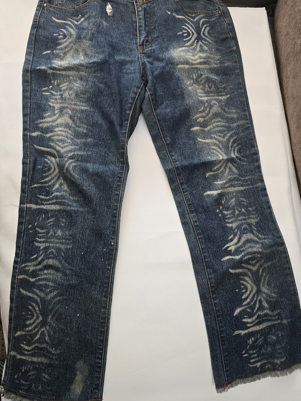 Vintage-style blue denim ieans with a tribal print pattern.